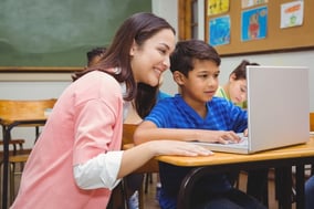 Happy teacher using laptop with student at the elementary school-1-2