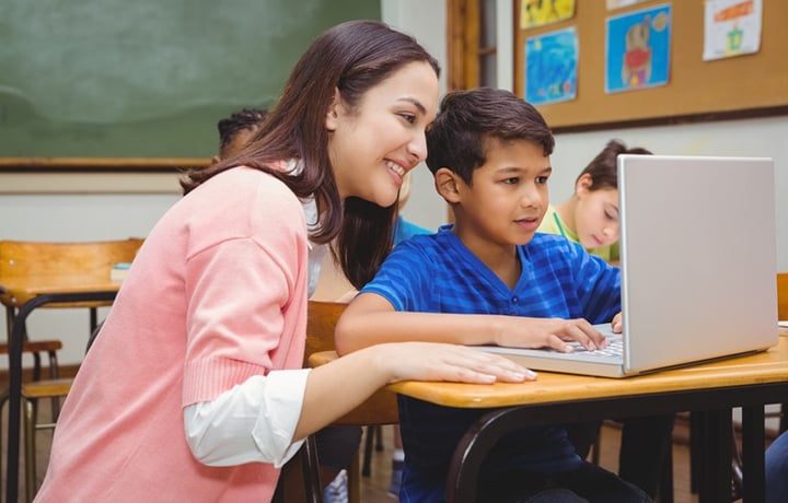 Happy teacher using laptop with student at the elementary school-720