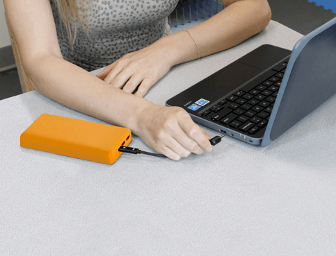 Hand connecting power bank to chrome book-1