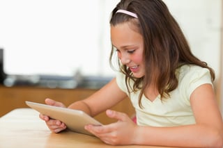 Girl at the kitchen table looking at tablet-1