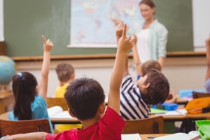 Pupils raising hand during geography lesson in classroom at the elementary school.jpeg