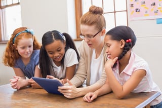 Teacher and pupils looking at tablet computer at the elementary school.jpeg