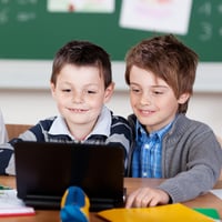 Two young classmates studying with laptop at the classroom